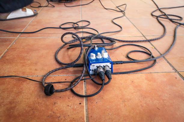 Cables on the floor plugged into a guitar pedal