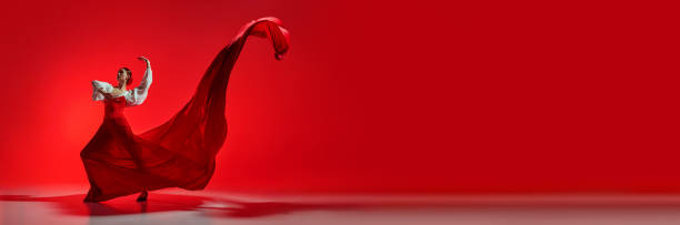 istock Passionate and elegant woman in vivid stage costume making creative performance against bright red background 2178693165