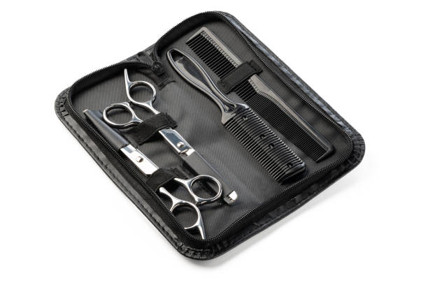 Hairdressing scissors with leather case on white background close up