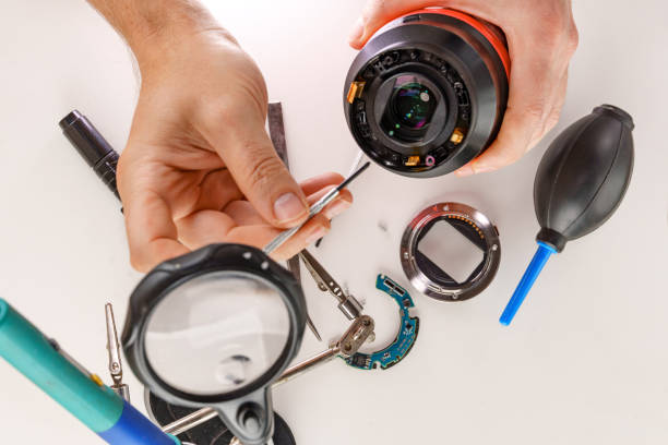 istock the hands of the master and a broken lens of a professional camera. 2178693896