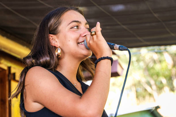 young singer woman on profile during a rehesearl with the music band. Low angle view