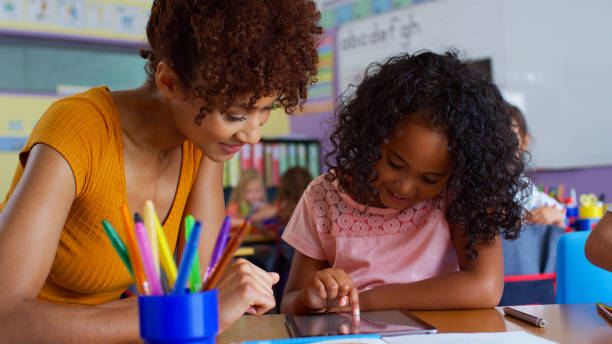 istock Elementary School Teacher And Female Pupil Drawing Using Digital Tablet In Classroom 2178694343