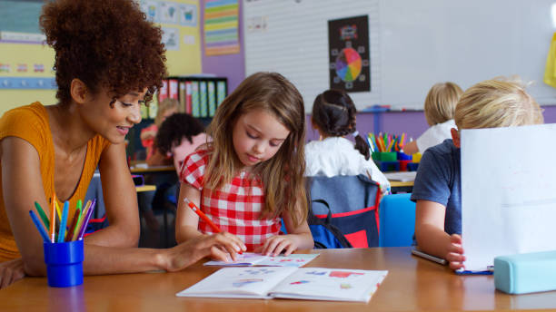 istock Female Elementary School Teacher Giving Female Pupil One To One Support In Classroom 2178694395