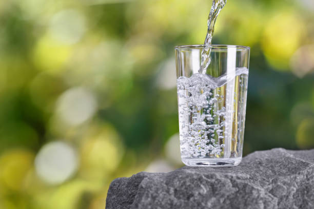 istock drinking water pouring into glass on stone 2178695769