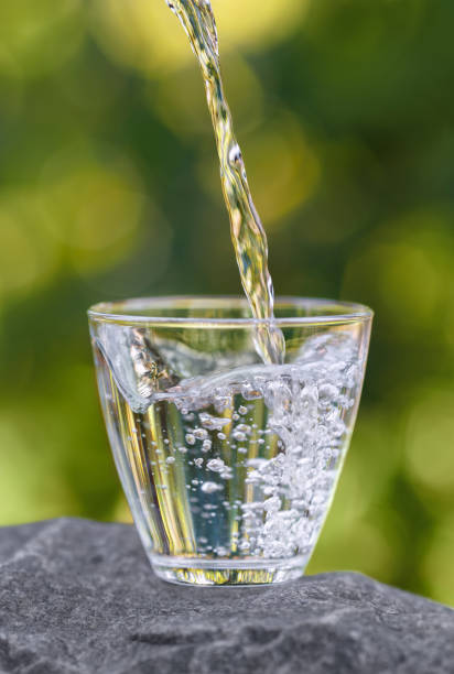 istock drinking water pouring into glass on stone 2178695784
