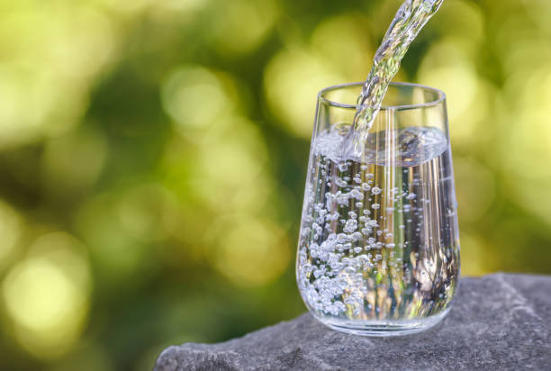 istock drinking water pouring into glass on stone 2178695786