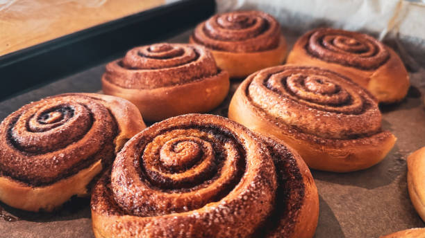 istock Delicious cinnamon rolls on baking paper, side view. Background of freshly baked cinnamon rolls. Close-up of homemade sweet pastries made from yeast dough 2178698825