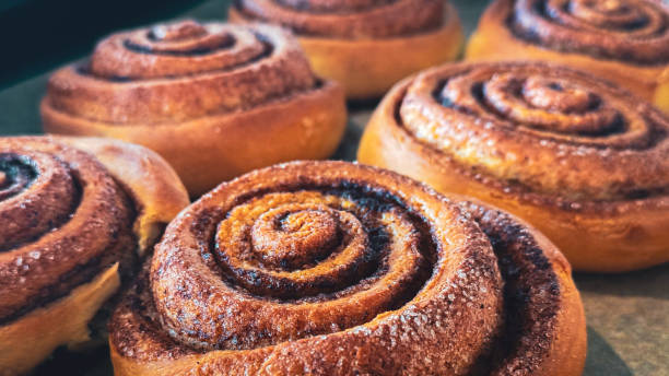 istock Delicious cinnamon rolls on baking paper, side view. Background of freshly baked cinnamon rolls. Close-up of homemade sweet pastries made from yeast dough 2178698858