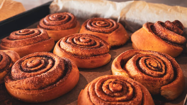 istock Delicious cinnamon rolls on baking paper, side view. Background of freshly baked cinnamon rolls. Close-up of homemade sweet pastries made from yeast dough 2178698863