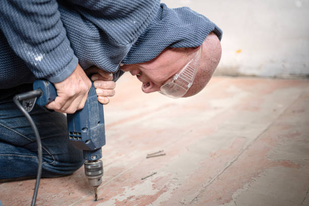 Man using water hose to clean the ground