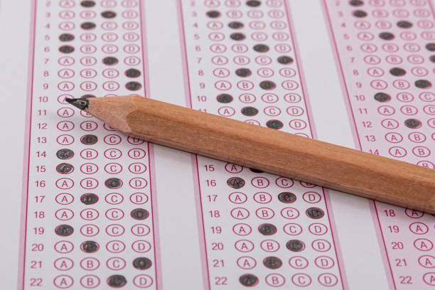 istock Exam, a hand taking an exam with a pen on an optical reader. Exam, an idea concept. Anxiety about the future, uncertainty. Multiple choice exam. Adults taking an exam. 2178702431