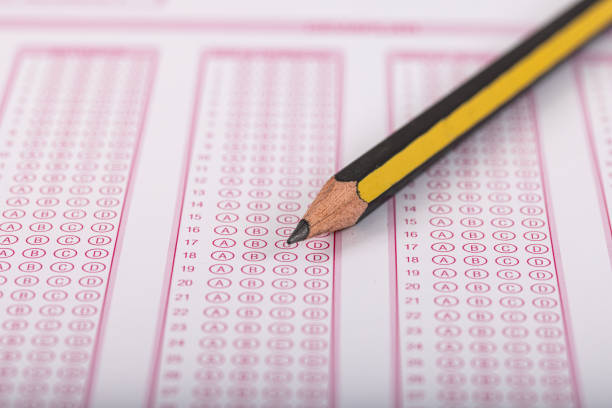 istock Exam, a hand taking an exam with a pen on an optical reader. Exam, an idea concept. Anxiety about the future, uncertainty. Multiple choice exam. Adults taking an exam. 2178702600