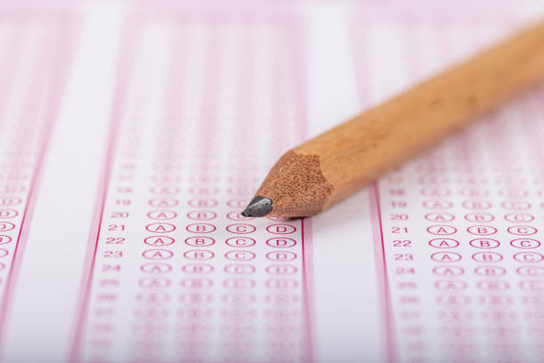 istock Exam, a hand taking an exam with a pen on an optical reader. Exam, an idea concept. Anxiety about the future, uncertainty. Multiple choice exam. Adults taking an exam. 2178702779