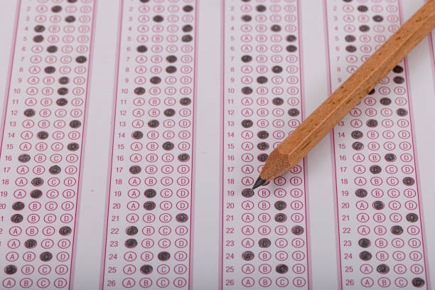 istock Exam, a hand taking an exam with a pen on an optical reader. Exam, an idea concept. Anxiety about the future, uncertainty. Multiple choice exam. Adults taking an exam. 2178702834