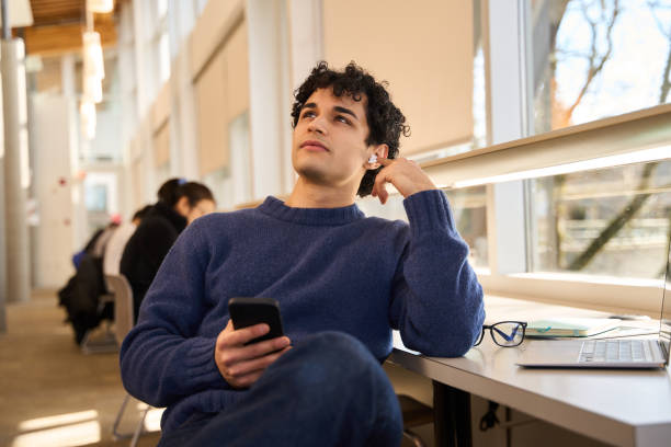 istock Pensive university student listening to podcast and relaxing in library 2178703025