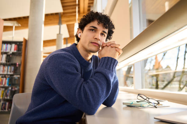istock Thoughtful student listening to podcast in college library 2178703074
