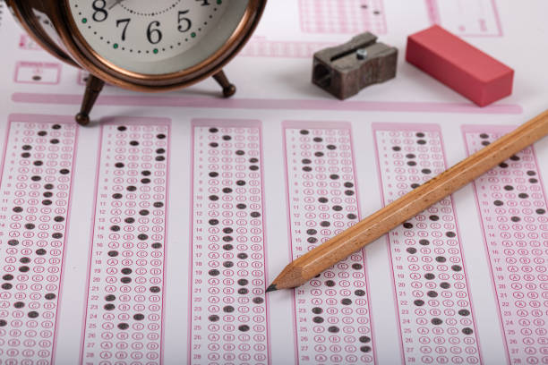 istock Exam, a hand taking an exam with a pen on an optical reader. Exam, an idea concept. Anxiety about the future, uncertainty. Multiple choice exam. Adults taking an exam. 2178703264
