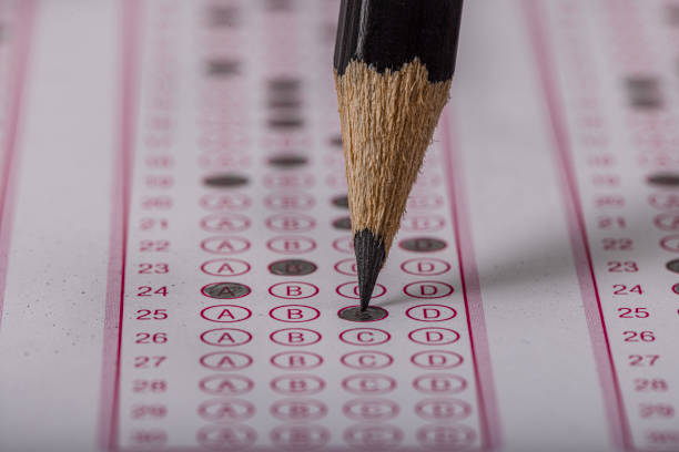 istock Exam, a hand taking an exam with a pen on an optical reader. Exam, an idea concept. Anxiety about the future, uncertainty. Multiple choice exam. Adults taking an exam. 2178703478