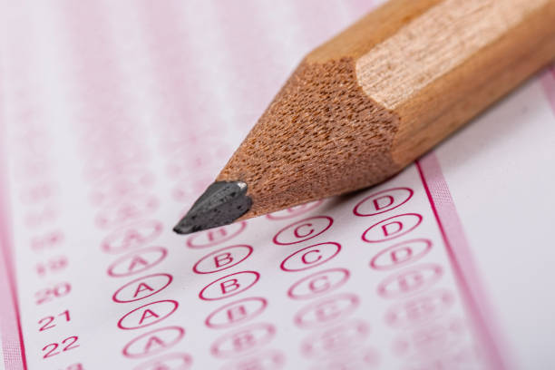 istock Exam, a hand taking an exam with a pen on an optical reader. Exam, an idea concept. Anxiety about the future, uncertainty. Multiple choice exam. Adults taking an exam. 2178703568