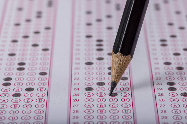 istock Exam, a hand taking an exam with a pen on an optical reader. Exam, an idea concept. Anxiety about the future, uncertainty. Multiple choice exam. Adults taking an exam. 2178703863