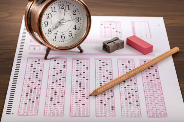 istock Exam, a hand taking an exam with a pen on an optical reader. Exam, an idea concept. Anxiety about the future, uncertainty. Multiple choice exam. Adults taking an exam. 2178703972