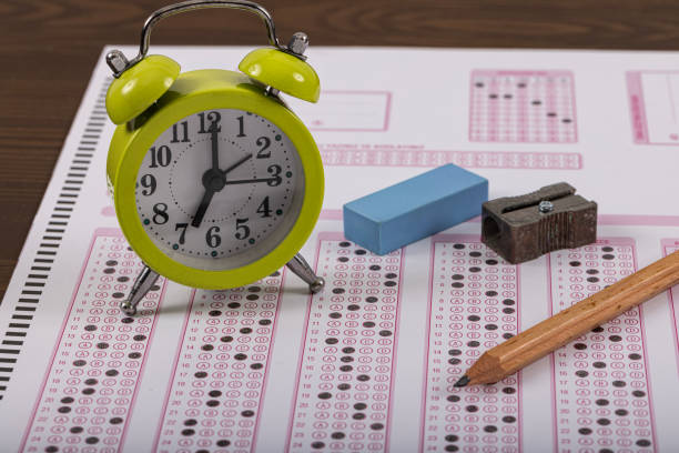 exam, a hand taking an exam with a pen on an optical reader. exam, an idea concept. anxiety about the future, uncertainty. multiple choice exam. adults taking an exam. - examen stockfoto's en -beelden