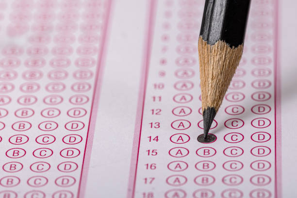 istock Exam, a hand taking an exam with a pen on an optical reader. Exam, an idea concept. Anxiety about the future, uncertainty. Multiple choice exam. Adults taking an exam. 2178704258