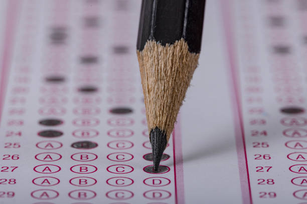 istock Exam, a hand taking an exam with a pen on an optical reader. Exam, an idea concept. Anxiety about the future, uncertainty. Multiple choice exam. Adults taking an exam. 2178704379