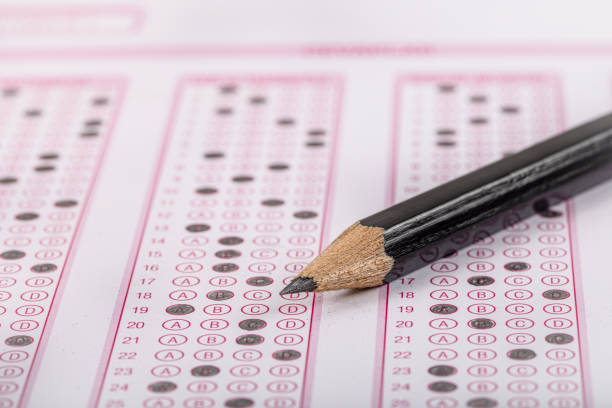 istock Exam, a hand taking an exam with a pen on an optical reader. Exam, an idea concept. Anxiety about the future, uncertainty. Multiple choice exam. Adults taking an exam. 2178704566