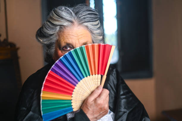 istock Senior actress is hiding her face with a colorful fan during a break on stage 2178705740