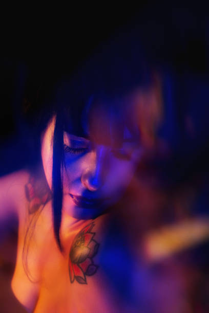 istock Young woman portrait looking down with colorful light effects 2178705979