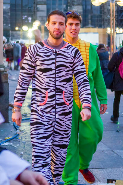 Two young men in colorful carnival costumes during the Rosenmontag carnival parade in Cologne.