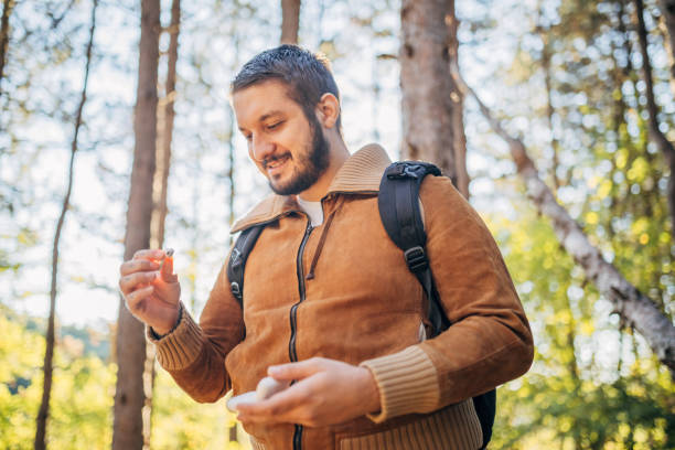 istock Young man connected with forest and putting earbuds 2178707910