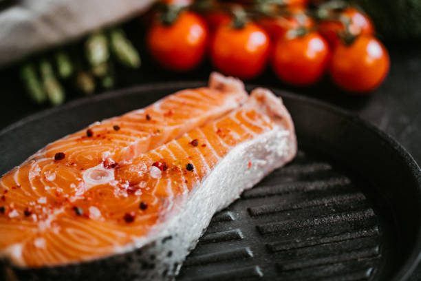Delicious raw salmon with vegetables on frying pan. Ready for grill