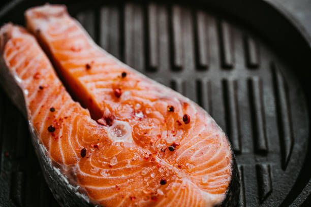 istock Delicious raw salmon with vegetables on frying pan. Ready for grill 2178710982