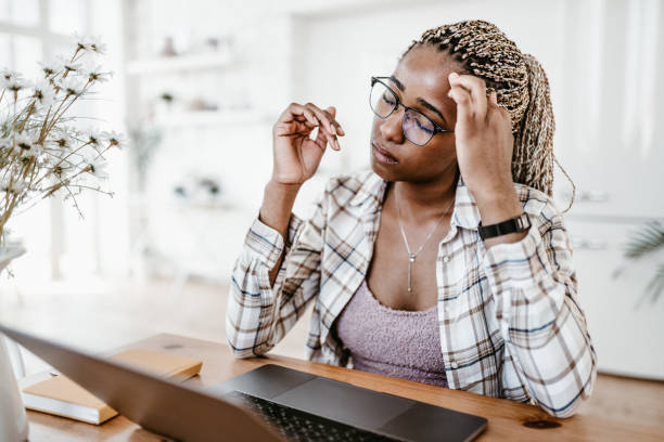 istock Stressed Woman Sitting at Desk with Hand on Forehead 2178711716