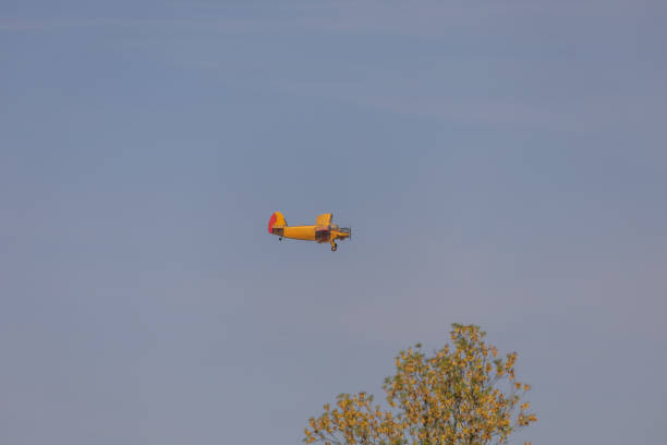 A Canadair firefighting plane flies low over a residential neighborhood in coastal Croatia during wildfire season. The contrast between modern buildings and the yellow aircraft highlights the urgency of fire prevention in populated areas. Ideal for editorial articles on climate response, emergency air support, or environmental issues in southern Europe.