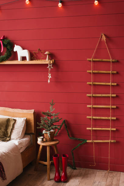 istock Red bedroom with a Christmas tree and a wreath on the wall 2178715221