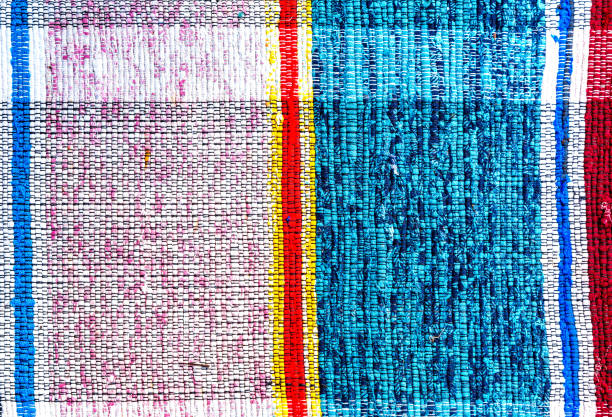 Old handmade homespun doormat from strips of cloth. Texture of a homemade rug from different fabrics