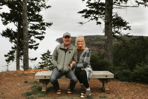 Couple Sitting On Bench With Scenic Ocean View