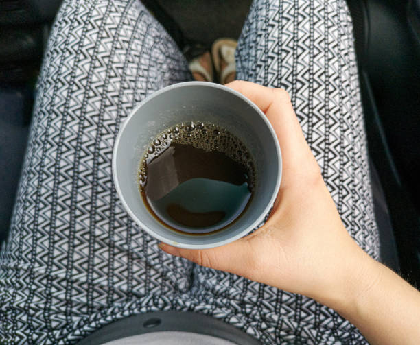 istock Holding travel cup with drink, car interior background. 2178718916