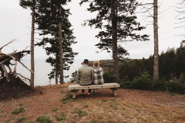Couple Sitting On Bench With Scenic Ocean View