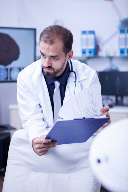 istock Close up portrait of brain surgeon looking into his notes from clipoard 2178723340