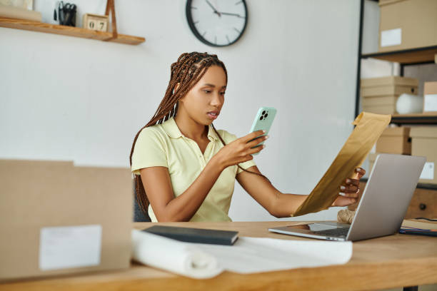 istock A young woman organizing mail at a post office desk while checking her phone 2178725249
