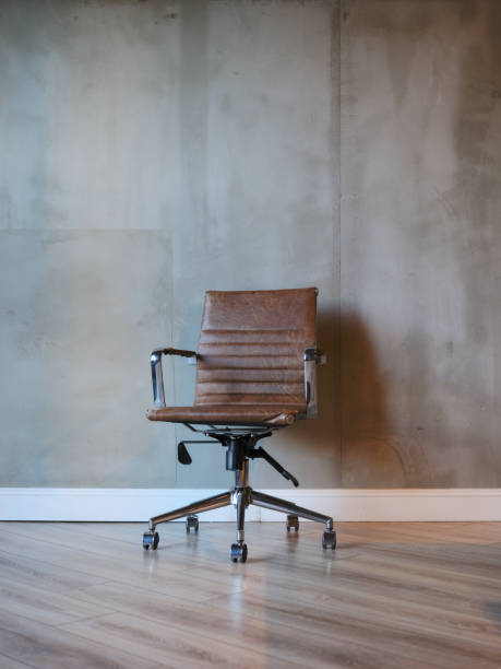 istock A modern brown leather office chair in an empty office room. 2178725257