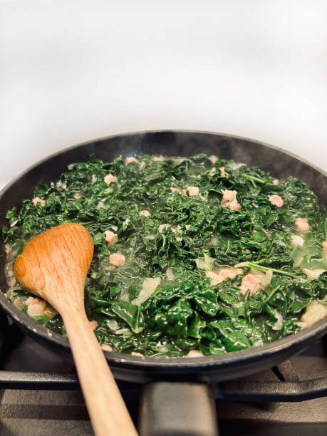 istock Sauteed kale in black cast iron pan with bacon cubes. 2178728604