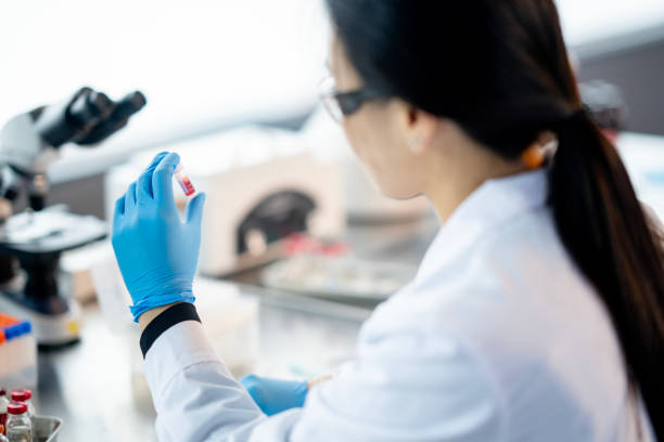 Analyzing Plasa Samples A female medical laboratory technician works independently as she analyzes plasma samples. She is wearing a lab coat as well as protective eyewear and gloves as she focuses on her task. oncology stock pictures, royalty-free photos & images