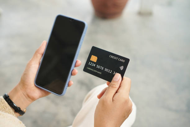 hand holding blank screen smartphone for mobile application and black credit card