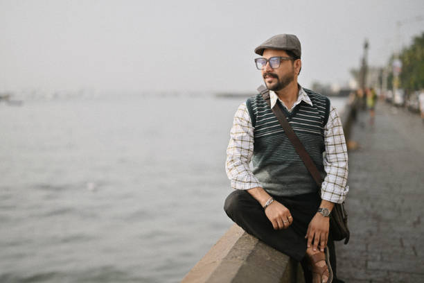Arabian man sitting on coastline. Space for copy.