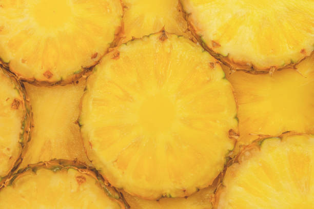 Pineapple juicy yellow slices as a background. Top view.